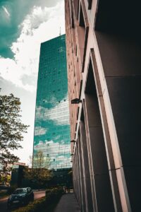 un grand bâtiment à côté d'une rue avec une voiture garée devant