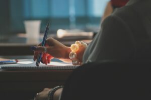 une femme écrivant sur un bloc-notes avec un stylo